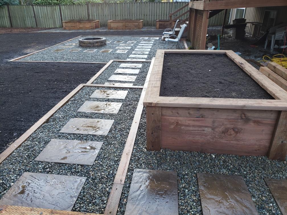 Fire Pit by Infinity Outdoor Services LLC in Des Moines WA. Built from bricks and surrounded by rocks. What a nice area for family fire gatherings!