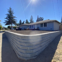 Sunlight brightens the dreams of this landscape owner! This retaining wall helped to restore a yard that was a knot of roots and dying plants, shrubs, and small trees. Sunlight brightens the dreams of this landscape owner! This retaining wall helped to restore a yard that was a knot of roots and dying plants, shrubs, and small trees.
