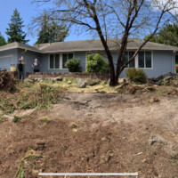 This is a before shot of a yard that ended up looking fantastic and symmetrical. This shows you the pile of roots and dying shrubs that got uprooted and replaced by a carefully graded and retained yard foundation. In a short time they'll have a beautiful new yard! A mound of roots where a landscape should appear