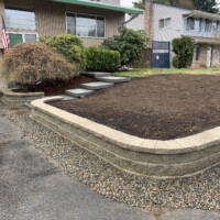 Square steps lead up behind retaining wall into front porch. Stairway Home
